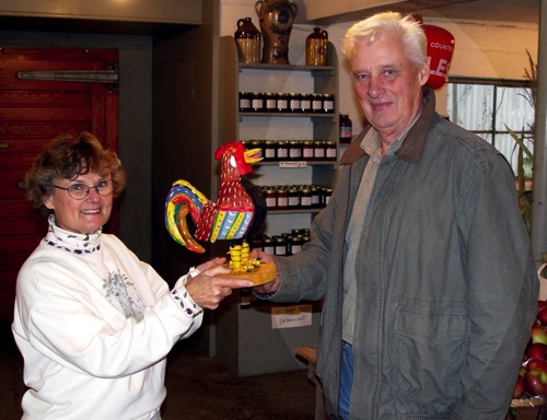 Norma presents Wolfgang's Rooster" raffle prize to Mark at Roe's Orchards - 11/19/2003 DCS-00490