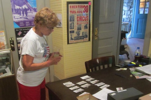 Norma checking Yard Sale name-tags. 2015-06-13.